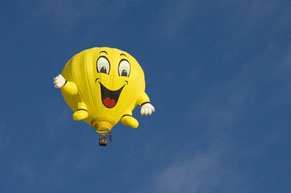 Yellow balloon rising in the sky