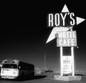 Bus parked next to Roy's motel café sign
