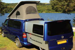 Blue VolksWagen Transporter DoubleBack Camper Van parked in field by lake